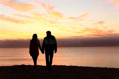 Couple walking in sunset stock photo. Image of walking - 1461080