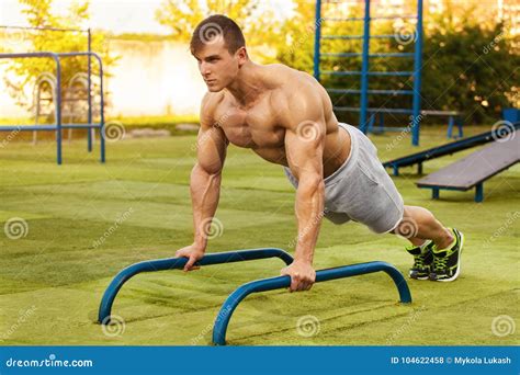 Fitness Man Doing Push-ups in the Stadium, Cross Training Workout. Sporty Male Training Outside ...