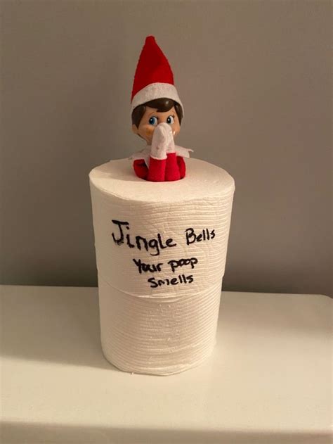 an elf is sitting on top of a roll of toilet paper that says, jingle ...