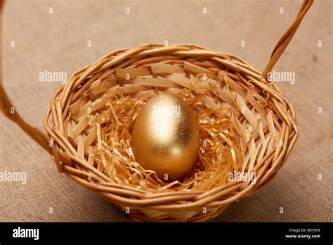 golden egg in a basket Stock Photo - Alamy