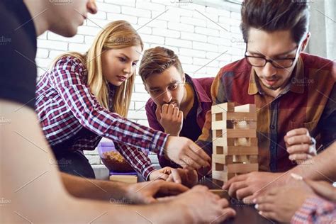 A cheerful group of friends play board games. | Group of friends, Board games, Friends photography