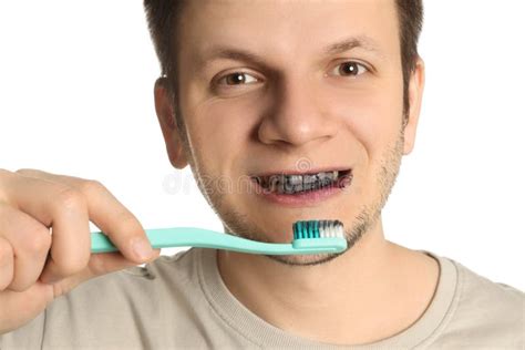 Man Brushing Teeth with Charcoal Toothpaste on White Background ...