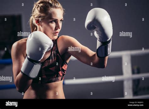 Female Boxer wearing gloves posing in boxing studio Stock Photo - Alamy