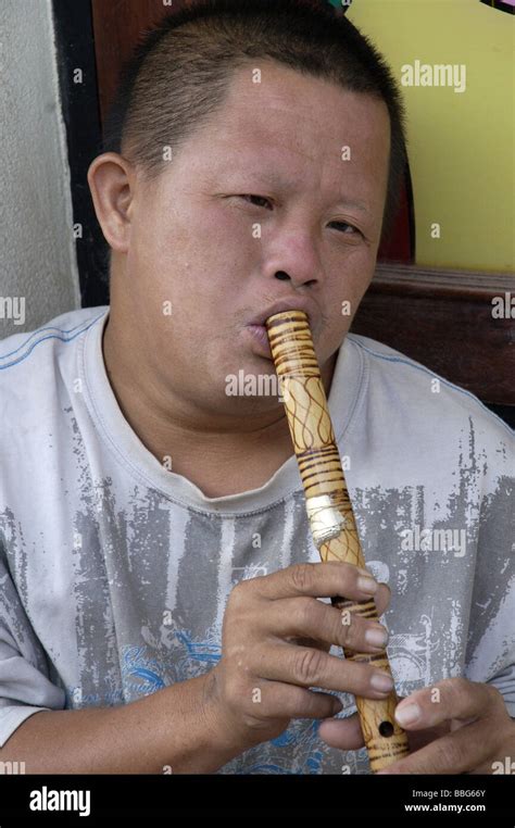 Laotian boy playing a wooden flute in Vientiane, Laos Stock Photo - Alamy