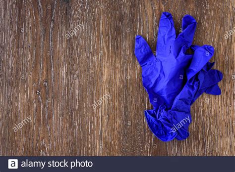 Dark blue nitrile exam gloves on a rustic wood table Stock Photo - Alamy