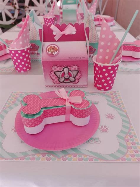 a table set up for a birthday party with pink and white polka dot paper cups