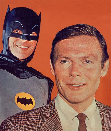 a man in a suit and batman mask next to another man wearing a suit with ...