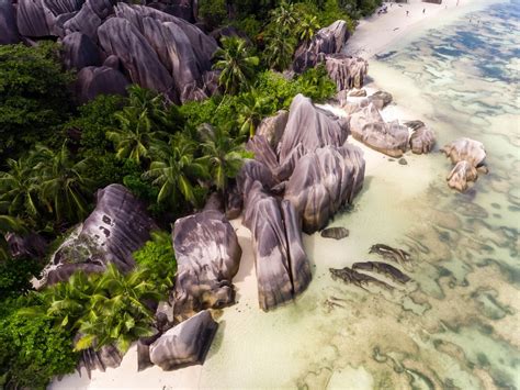 Aerial photography shows granite rocks at the shore of Anse Source d ...