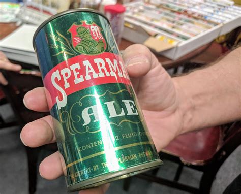 a person holding a can of spearmin ale in their hand