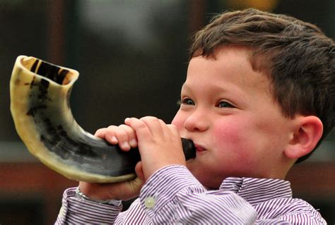 Young boy blowing a shofar on Rosh Hashanah | JewishBoston