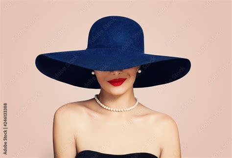 Beautiful smiling woman in elegant hat on pink background. Stylish girl with red lips makeup ...