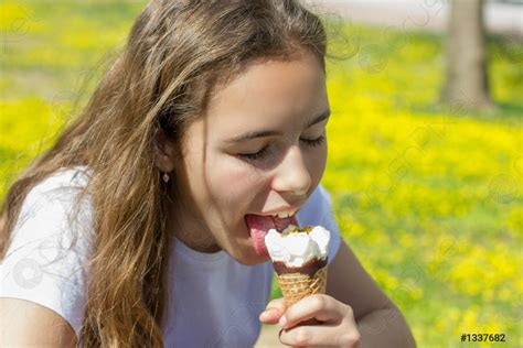 Beautiful teen girl eating ice cream in a waffle cone - stock photo 1337682 | Crushpixel