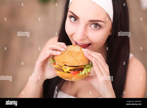 Young woman in a fine dining restaurant eat a hamburger, she behaves improperly Stock Photo - Alamy