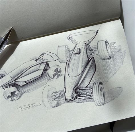 a pencil drawing of a race car on top of a piece of paper next to a pen