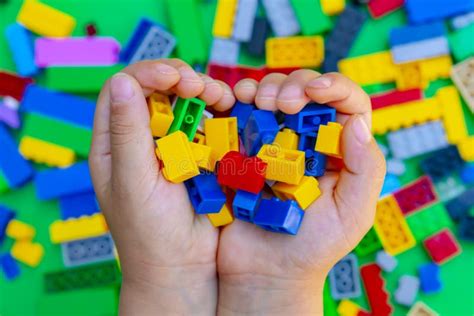 A Kid Holding Small Pieces Of Interlocking Plastic Colorful Bricks Toy ...