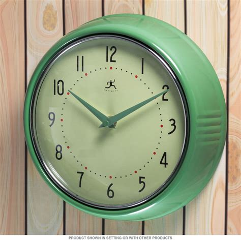 a green wall clock hanging on the side of a wooden wall
