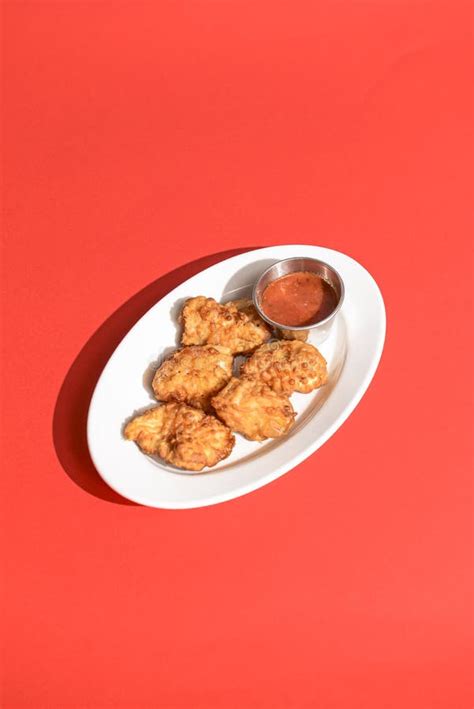 Golden Chicken Nuggets in a White Plate with Sauce. Served Over Bright ...