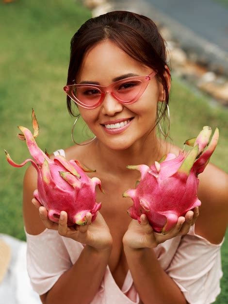 Free Photo | Cute asian woman holding pink dragon fruits in hands.