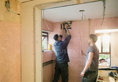 Construction workers installing copper pipe in house — working ...