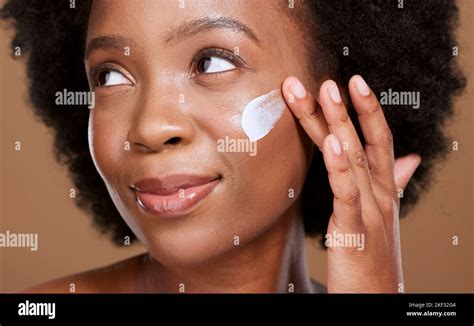 Black woman, face cream and beauty, sunscreen makeup product and luxury facial treatment on ...