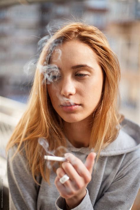 "Attractive Young Woman Smoking Cigarette" by Stocksy Contributor "MEM Studio" - Stocksy