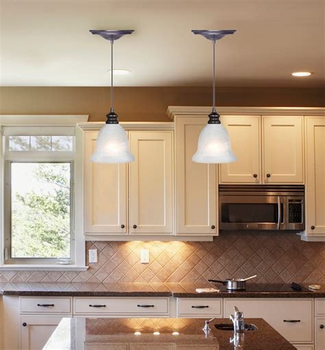 a kitchen with two lights hanging from the ceiling