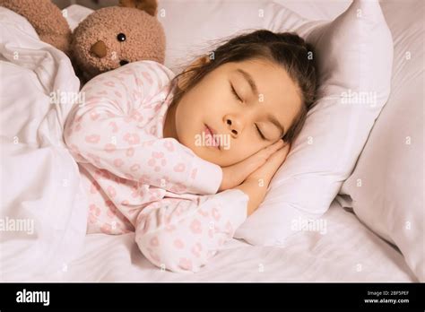 Cute little Asian girl sleeping in bed at night Stock Photo - Alamy