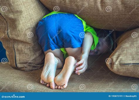 Rear View, Back Legs Feet of a Child Hiding Under a Pillow, Offended Boy in Bad Mood or Playing ...