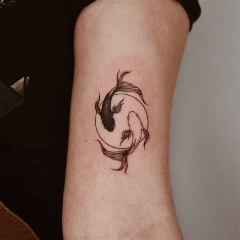 Yin yang koi fish tattoo located on the bicep.