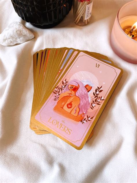 a deck of cards sitting on top of a bed next to a candle and bowl