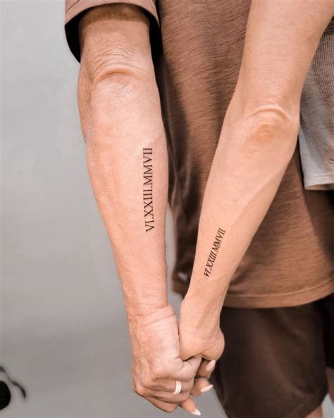 Matching date in roman numerals tattoo for couple.
