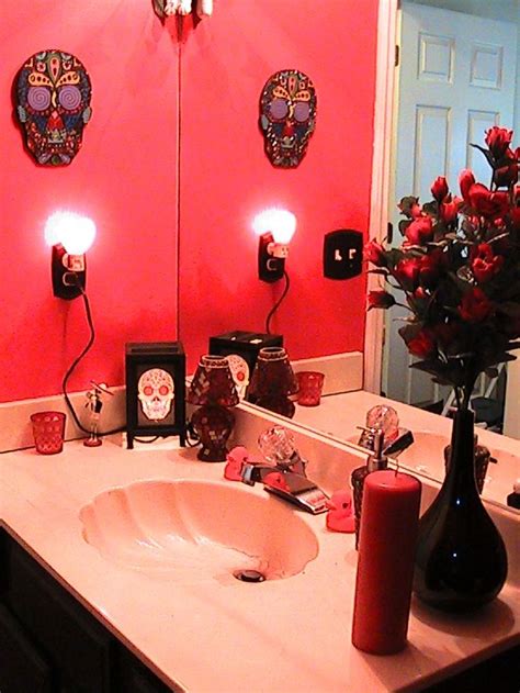 a bathroom with red walls and white counter tops, decorated with flowers in vases