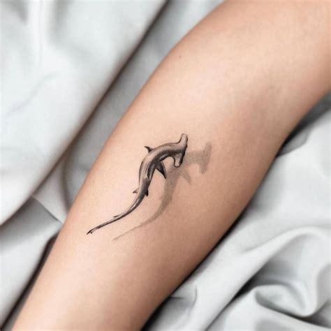 Micro-realistic hammerhead shark tattoo on the forearm.