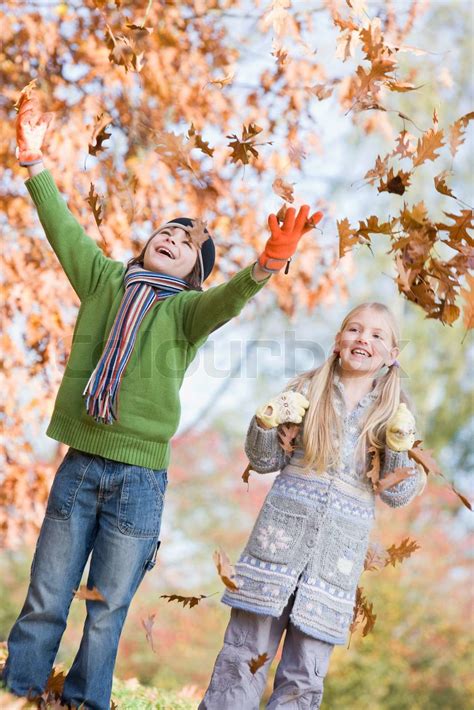 Two children throwing autumn leaves in the air | Stock image | Colourbox