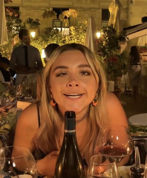 a woman sitting at a table with wine glasses and bottles in front of ...