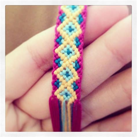 a person is holding a colorful bracelet in their hand