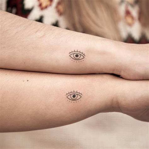 Matching minimalistic evil eye tattoo for sisters.