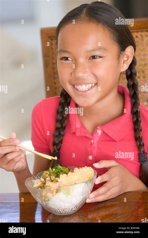 Young girl in dining room eating Chinese food smiling Stock Photo - Alamy