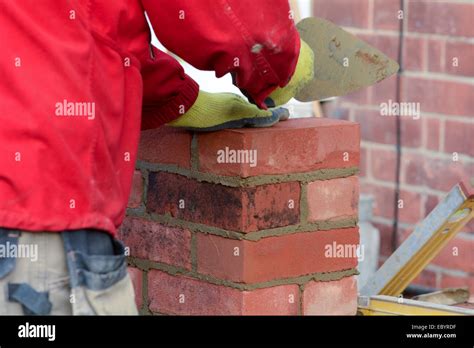 Bricklaying checking brick is level Stock Photo - Alamy