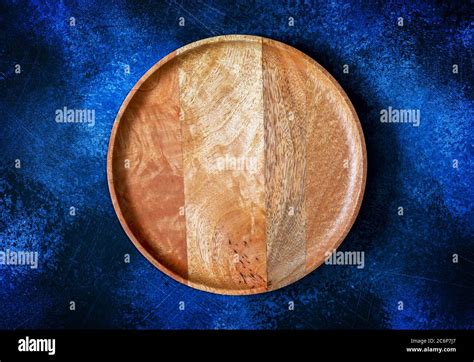 Top view of wooden round plate for pizza on contrast dark blue background Stock Photo - Alamy