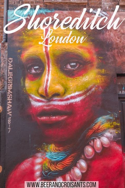 a painting on the side of a building with a woman's face painted in bright colors