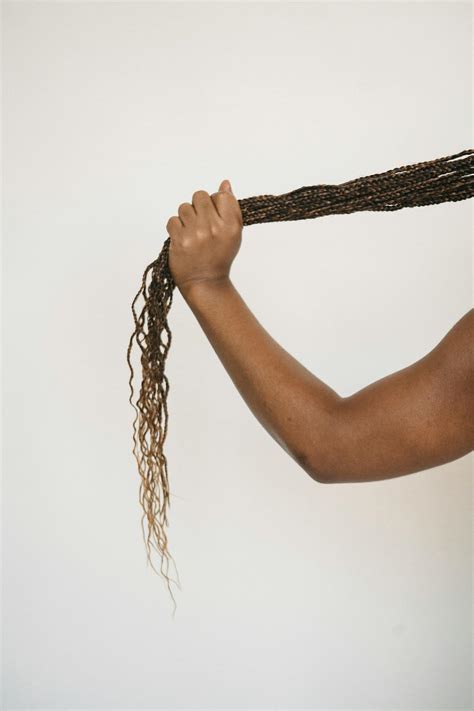 Crop faceless ethnic person touching ponytail of African braids · Free Stock Photo