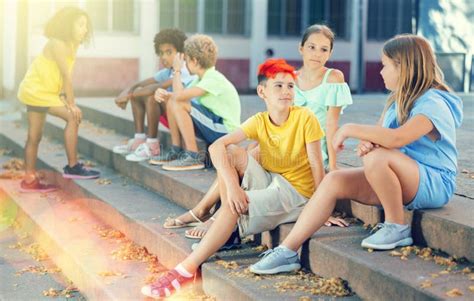 Positive Tweenagers Friendly Blabbing while Sitting on Steps Outdoors Stock Image - Image of ...