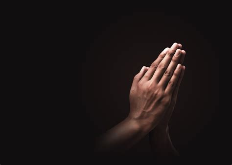 Praying hands with faith in religion and belief in God on dark background. Power of hope or love ...