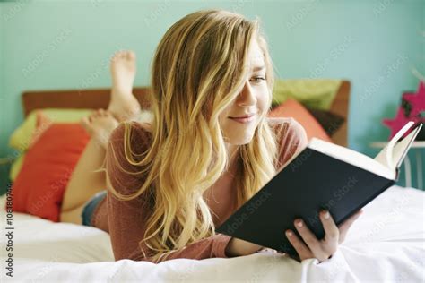 Caucasian woman reading book on bed Stock Photo | Adobe Stock