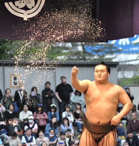 Sumo Champion Hakuho tosses a handfull of salt to purify the ring at an outdoor sumo event in ...