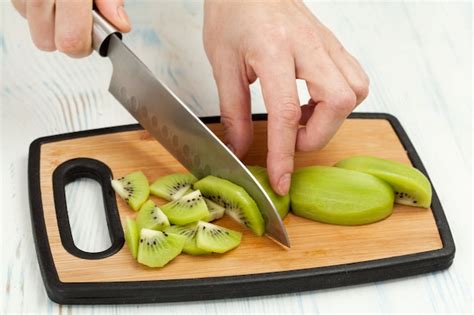 Chef's male hand cutting the tomato with sharp knife on board Photo ...