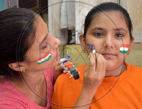 Image of Girls paint their cheeks in tri-color national flag colours ahead of Independence day ...