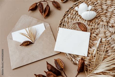 Minimal aesthetic background with blank card and dry floral branch on beige background. Wedding ...
