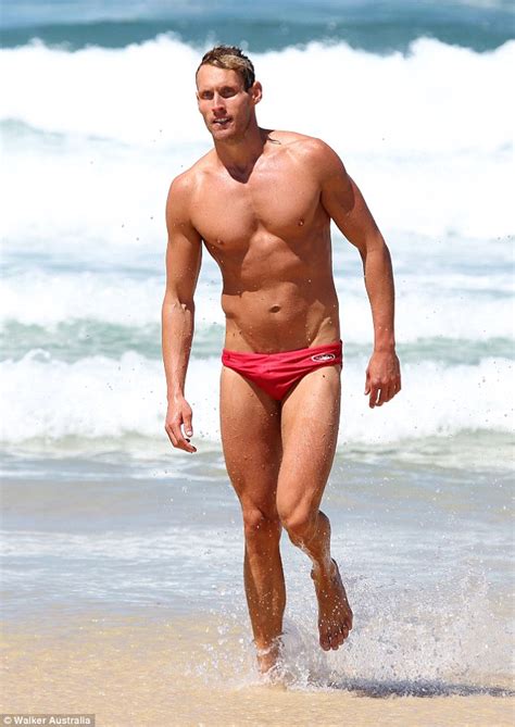 Luke Hines displays his six-pack as he goes for a swim in Bondi wearing red budgie smugglers ...